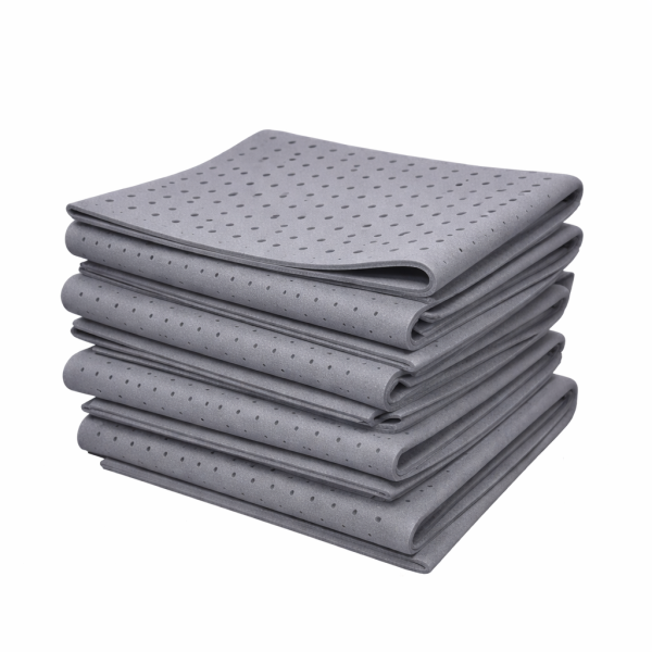 Stack of grey natural latex foam sheets with visible ventilation pinholes on surface, neatly folded layers, studio background